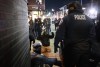 A protester raises their arms on the ground as law enforcement make arrests after declaring an unlawful assembly during a noise demonstration outside the Graduate by Hilton Minneapolis hotel on Wednesday, Jan. 28, 2026, in Minneapolis. (AP Photo/Adam Gray)