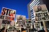 Demonstrators hold signs during a rally against federal immigration enforcement at Federal Courthouse Plaza on Tuesday, Jan. 27, 2026, in Minneapolis. (AP Photo/Adam Gray)