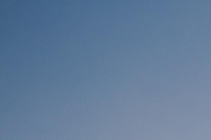 Faro de SeaWorld Orlando al atardecer con laguna y atracciones del parque