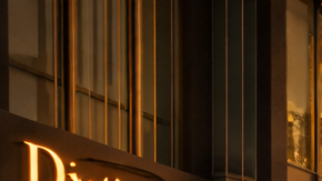 Calle de apariencia dorada en Dubái con tiendas de lujo y el skyline moderno de la ciudad.