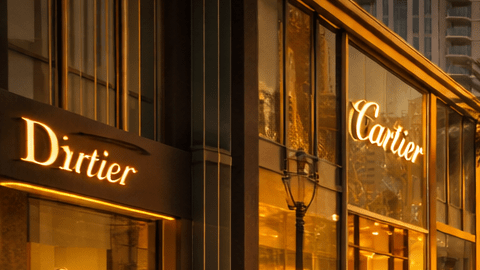 Calle de apariencia dorada en Dubái con tiendas de lujo y el skyline moderno de la ciudad.