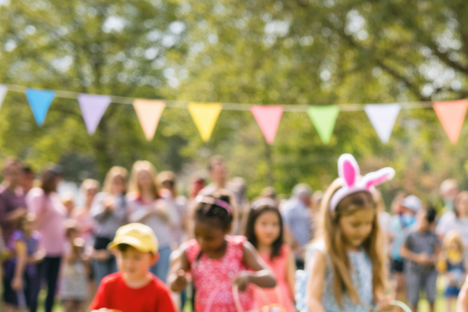 Cómo hacer una búsqueda del tesoro en Pascuas Niños participando en una Easter egg hunt en un parque público con cartel que dice Easter Egg Hunt