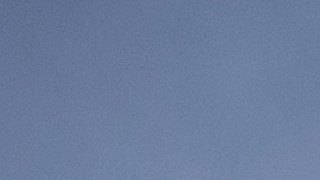 Silueta de un luchador enmascarado que vuela por los aires, contra el sol, mientras otro luchador observa desde el ring durante una función de lucha libre en Ciudad de México.