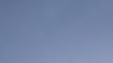 Silueta de un luchador enmascarado que vuela por los aires, contra el sol, mientras otro luchador observa desde el ring durante una función de lucha libre en Ciudad de México.