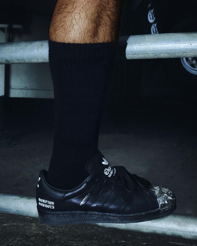 Sneaker negro de la colección Willy Chavarria x Adidas con detalle de Compton Cowboys en el lateral