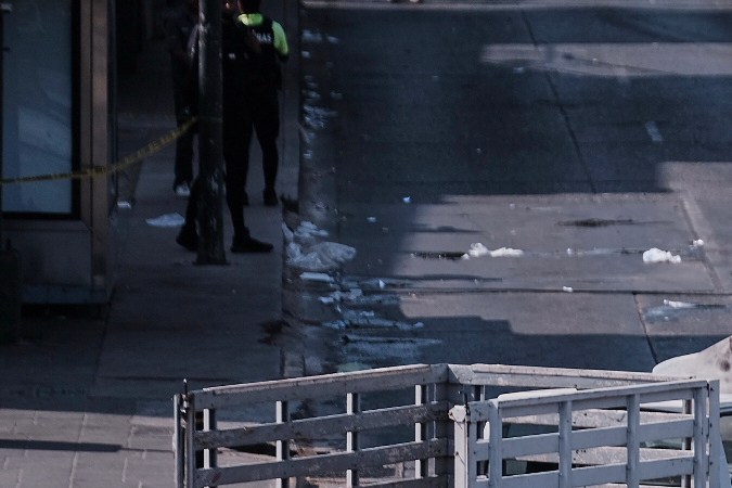 Policías resguardan una avenida en Guadalajara junto a un vehículo calcinado tras un enfrentamiento.