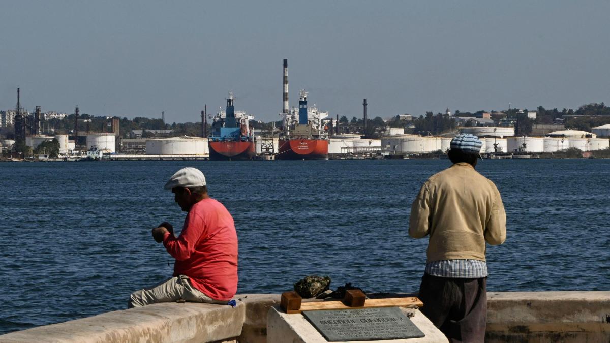 Vista de la costa de Cuba con instalaciones petroleras y personas frente al mar en medio de la tensión por restricciones al suministro de combustible