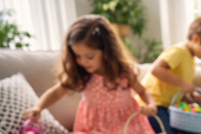 Niños participando en una Easter egg hunt en el interior de la casa siguiendo un mapa del tesoro