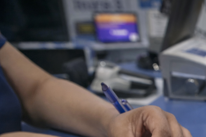 Persona registrando una tarjeta SIM en México con formulario oficial, pasaporte mexicano y teléfono móvil sobre mostrador