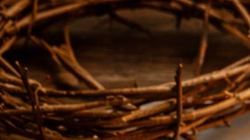 Calendario de abril con fecha marcada de Viernes Santo junto a una cruz de madera, Biblia y elementos religiosos de Semana Santa.