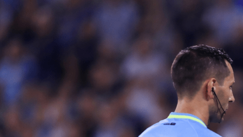 Árbitro revisando una jugada en el monitor del VAR durante un partido de fútbol en estadio