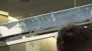 In this May 30, 2019 photo immigrant families show paperwork to enter an immigration court in an office building in downtown Los Angeles. U.S. authorities are fast-tracking families' cases through the immigration courts in a pilot program aimed at discouraging many from making the journey to seek refuge in the United States. (AP Photo/Richard Vogel)