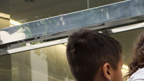 In this May 30, 2019 photo immigrant families show paperwork to enter an immigration court in an office building in downtown Los Angeles. U.S. authorities are fast-tracking families' cases through the immigration courts in a pilot program aimed at discouraging many from making the journey to seek refuge in the United States. (AP Photo/Richard Vogel)