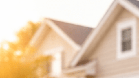 Familia latina celebrando la compra de su primera casa frente a una vivienda en Estados Unidos