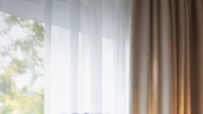 Grupo de amigos latinos celebrando un gol mientras ven un partido de fútbol en un televisor grande en sala de estar