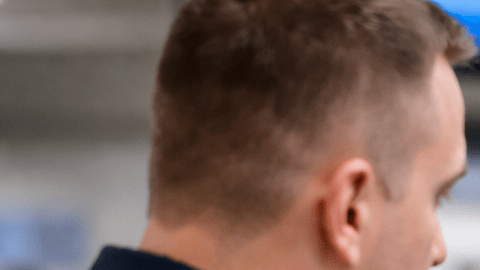 Hombre en aeropuerto mostrando su pasaporte a un agente de inmigración durante control