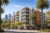 Edificio moderno de apartamentos en California con palmeras y skyline urbano al fondo