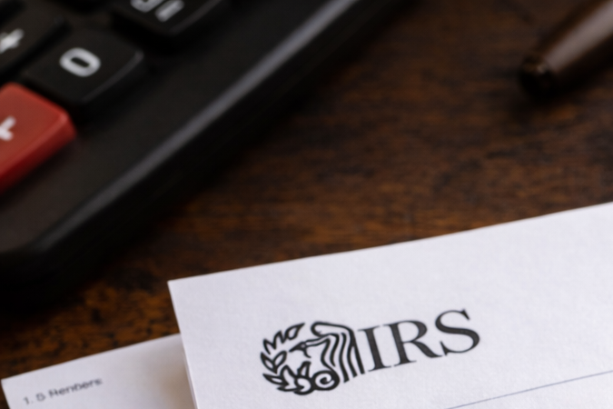 Carta del IRS con aviso de embargo sobre documentos financieros y dinero en una mesa