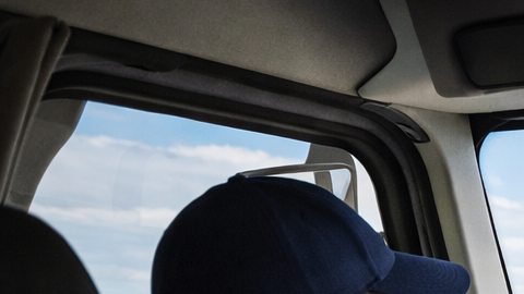 Persona conduciendo un camión con instructor en una autopista de Texas durante entrenamiento CDL