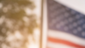 Hombre latino con documentos en la mano frente a edificio gubernamental en Estados Unidos