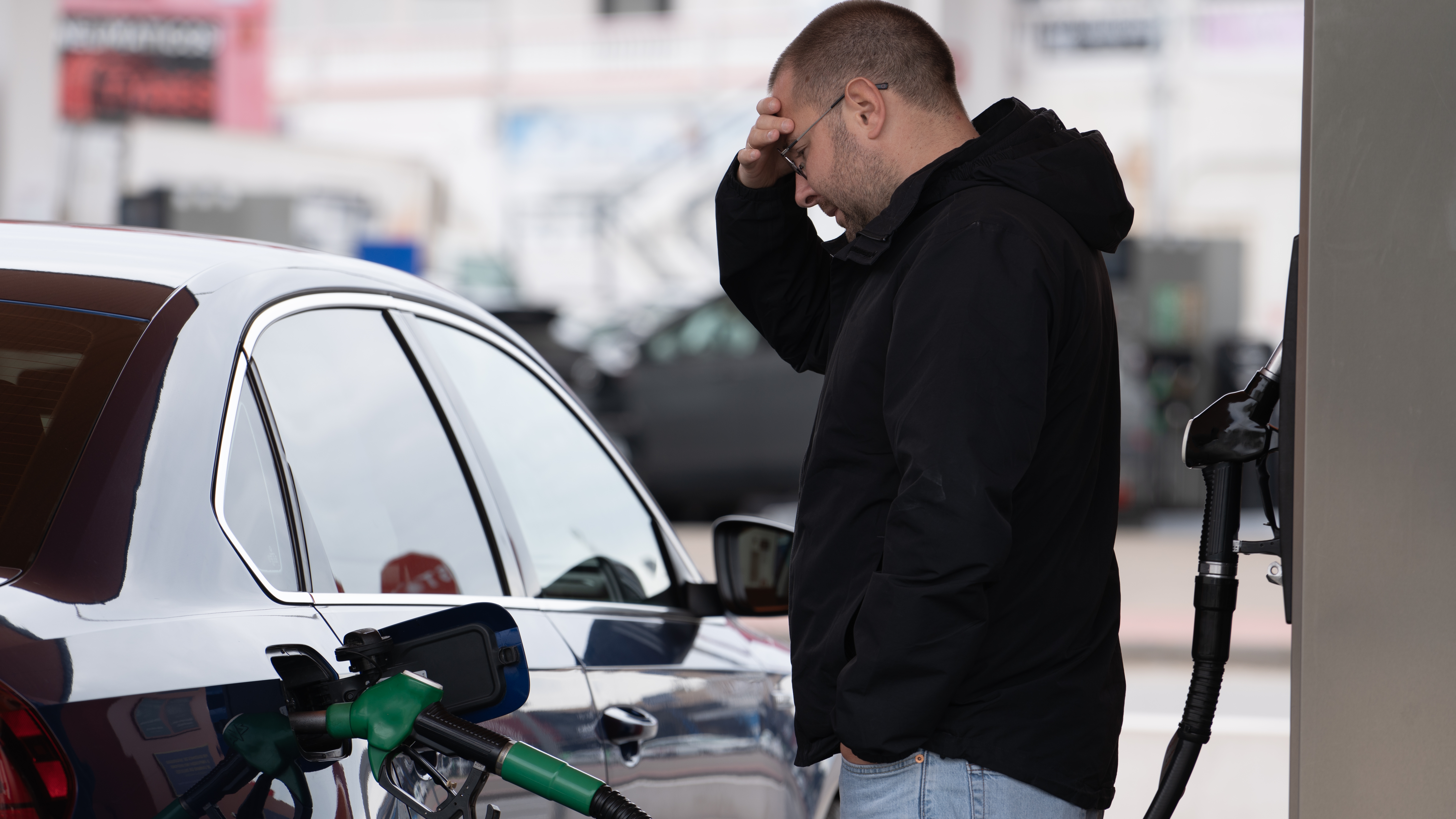 Frustrated,Man,Refueling,Car,At,Gas,Station,Holding,His,Head.