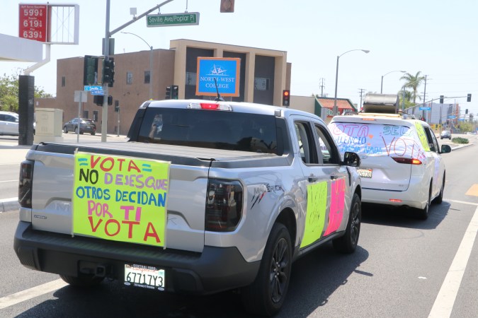 Vehículos con consignas en la caravana electoral realizada en el sureste de Los Ángeles el día previo a las elecciones primarias de California.