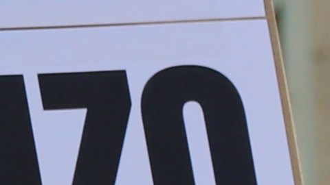 Julia González sostiene un cartel que condena los asesinatos por parte de agentes de inmigración afuera del Ayuntamiento de Los Ángeles durante una protesta contra ICE.