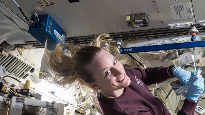 La astronauta de la NASA Kate Rubins examina microbios presentes en la Estación Espacial Internacional.