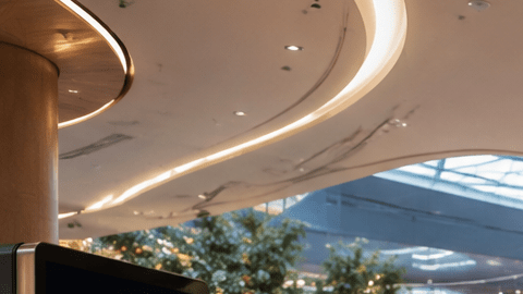 Automóvil eléctrico circulando dentro de un moderno centro comercial entre tiendas