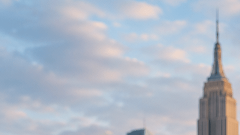 Grupo de trabajadores de distintos rubros posando frente al skyline de Nueva York, en una imagen ilustrativa sobre empleos para hispanos