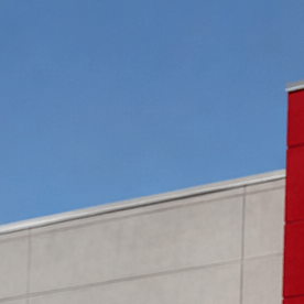 Fachada exterior de una tienda Target con su característico frente rojo, puertas de entrada vidriadas y un carrito rojo en primer plano.