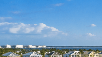 Comunidad residencial estilo resort con piscina, palmeras y viviendas, imagen ilustrativa del proyecto Latitude Margaritaville Galveston Bay en Texas.