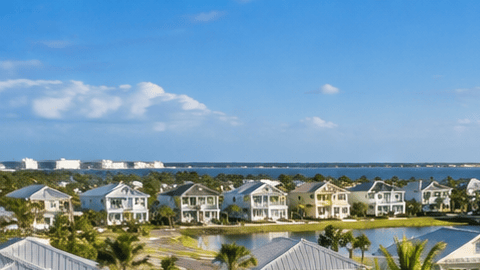Comunidad residencial estilo resort con piscina, palmeras y viviendas, imagen ilustrativa del proyecto Latitude Margaritaville Galveston Bay en Texas.